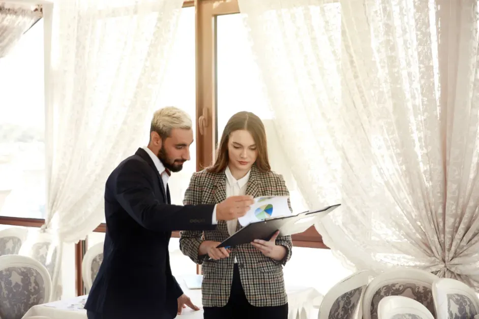 Two hotel staff members reviewing wedding booking details together
